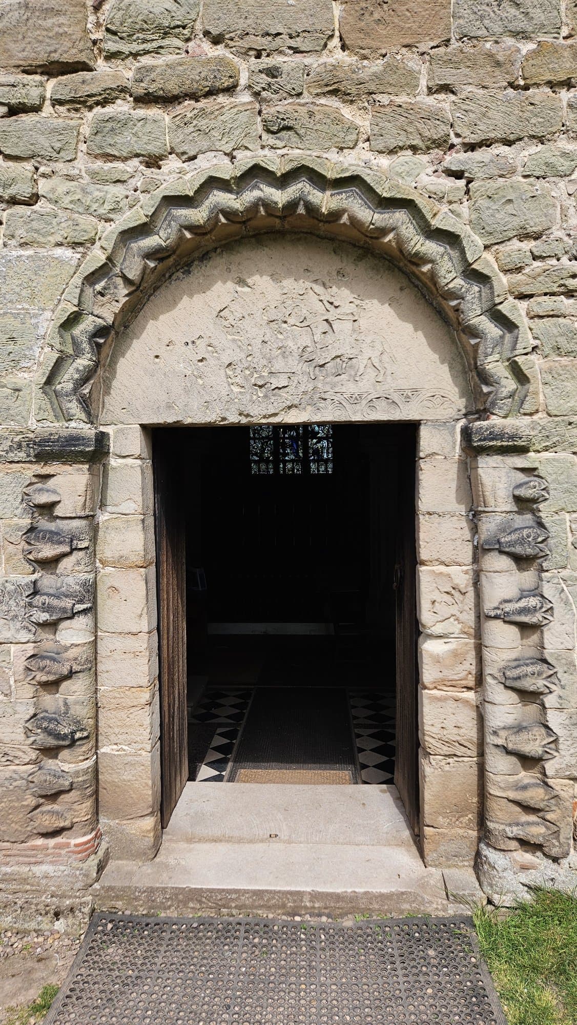 The Norman South doorway has a round-headed arch decorated with a zigzag pattern.