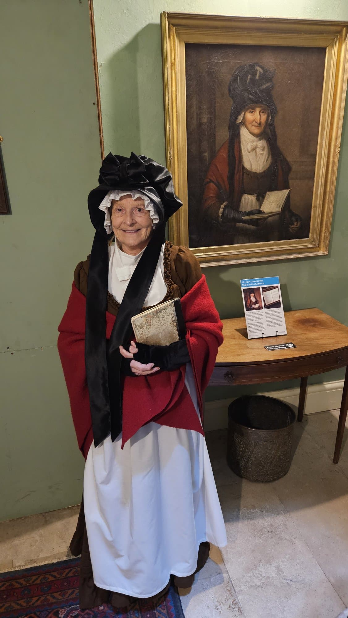 National Trust volunteer Anne gave us a fascinating insight into Kedleston's famous housekeep Mary Garnett.

She was housekeeper at Kedleston for an extraordinary 43 years, from 1766 until her death in 1809 at the age of 85. Almost nothing is known of her life before she took up the post in her forties, which is part of what makes her such an intriguing figure.

From the moment Kedleston was completed, Sir Nathaniel opened it to "respectable" visitors, and Mrs Garnett was the one who guided them through. Warm and obliging, she was highly regarded, with a reputation as an especially welcoming and informative guide, and she conducted some genuinely famous people around the rooms — including Samuel Johnson and James Boswell, who visited together in 1777.

What makes her remarkable, though, is the portrait. Around 1800, Thomas Barber the elder of Nottingham painted her oil portrait, set in the Marble Hall — and this was extraordinarily unusual for a servant. The painting was almost certainly commissioned by Lord Scarsdale himself, which suggests genuine personal regard rather than mere convention.

She is buried near the Curzon family in All Saints' Church in the grounds - another mark of how unusually she was regarded. There are persistent local stories that there was something between her and Lord Scarsdale (or some other secret) that explains her prominence, the portrait, and the burial spot, but no documentary evidence has ever surfaced.